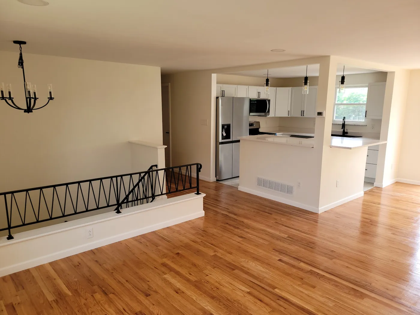 Open kitchen and living area with refinished hardwood floors